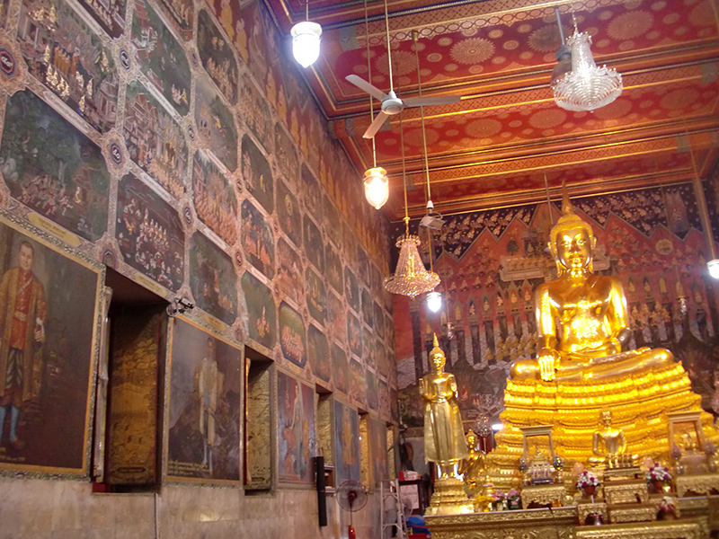 バンコク・トンブリ地区、ワット・パークナーム寺院の仏像と壁画。壁の上部には仏教を題材とした伝統的な絵が、その下には王族の肖像画が描かれている。（筆者撮影）